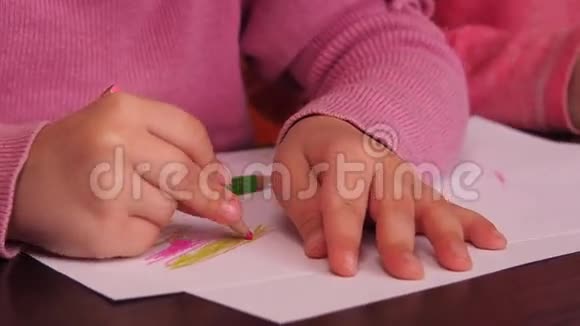 孩子们画铅笔两个小女孩用蜡笔在纸上画画视频的预览图