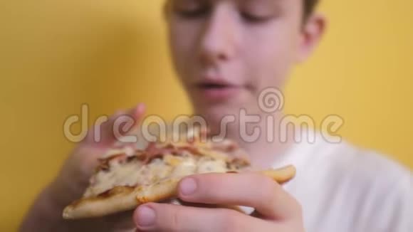 快乐的小男孩吃一片披萨的概念少年男孩饿了吃一片生活方式披萨慢速视频视频的预览图