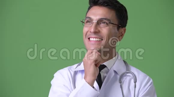 年轻英俊的西班牙男子医生绿色背景视频的预览图
