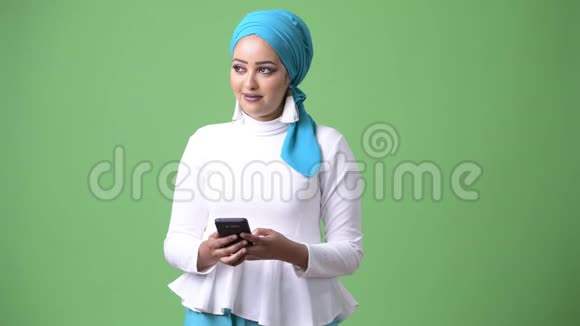 年轻漂亮的非洲穆斯林妇女带绿色背景的彩色钥匙视频的预览图