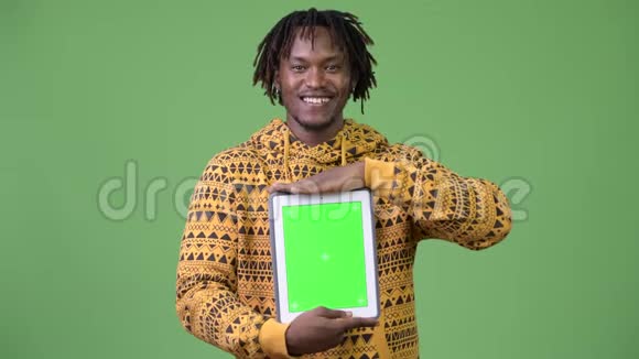 年轻快乐英俊的非洲男子展示数码平板电脑视频的预览图