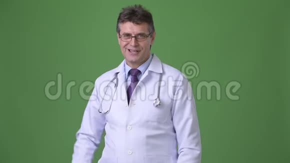 成熟英俊的医生绿色背景视频的预览图