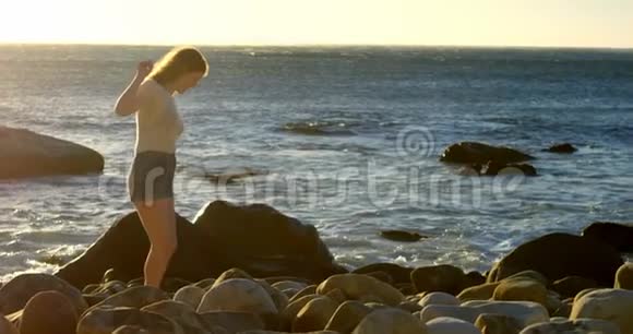 阳光明媚的一天女人在海滩上散步视频的预览图