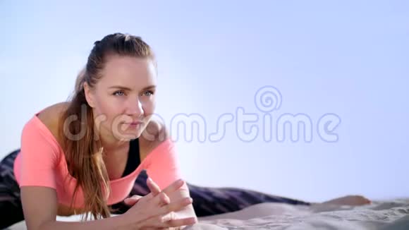 健康年轻的美女伸展身体在日出的时候在海滩上练习瑜伽为平衡和平衡做运动视频的预览图