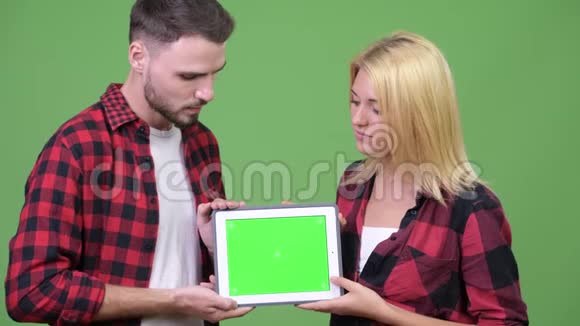 年轻夫妇一起展示数字平板电脑视频的预览图