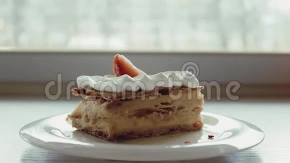 经典的法式甜点millefeuille放在木板上拿破仑蛋糕放在托盘或桌子上上面有薄荷和一杯咖啡和鲜花视频的预览图