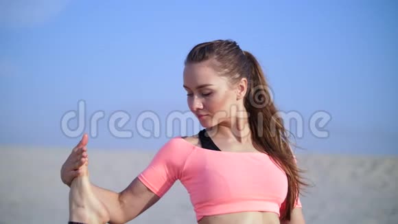 健康年轻的美女伸展身体在日出的时候在海滩上练习瑜伽为平衡和平衡做运动视频的预览图