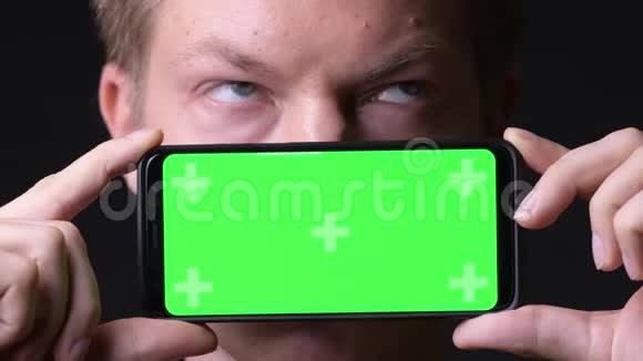 年轻的帅哥用手机用绿色屏幕色键视频的预览图