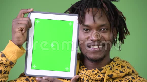年轻快乐英俊的非洲男子展示数码平板电脑视频的预览图