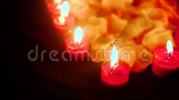 蜡烛用花瓣燃烧的脚印情人节视频的预览图