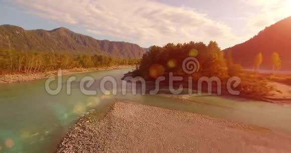 4kUHD鸟瞰图在阳光明媚的夏天早晨低飞过新鲜寒冷的山河绿树和太阳光视频的预览图