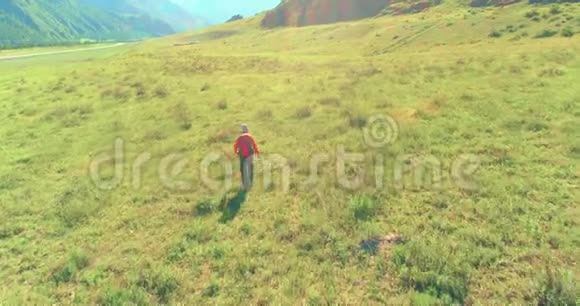 乘坐背包旅行徒步旅行游客步行穿过绿色的山野夏日的乡村山谷视频的预览图