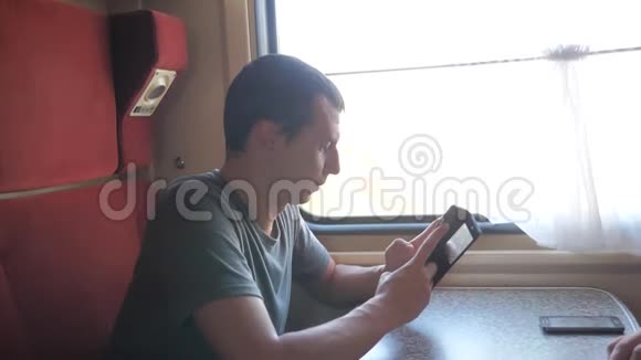 休闲男子从手机屏幕阅读同时阅读短信旅行的火车旅行车慢速视频视频的预览图