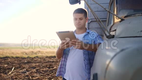 聪明的农业司机男子农民司机站在卡车附近的数字平板电脑慢动作视频肖像视频的预览图