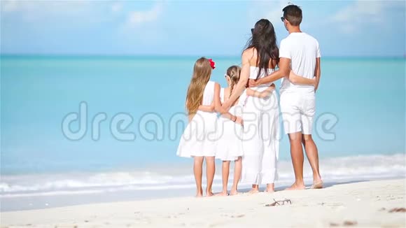 白色海滩上幸福美丽的家庭视频的预览图