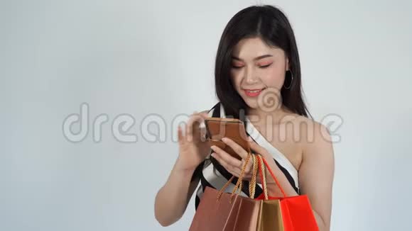 购物妇女拿着包使用智能手机视频的预览图