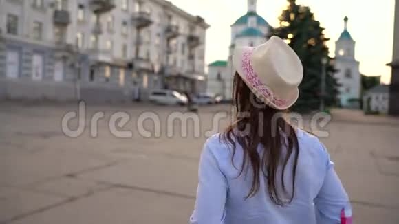 女孩正在城市里走来走去用摄像机拍摄风景视频的预览图