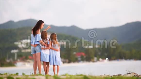 美丽的母亲和海滩上可爱的小女儿视频的预览图