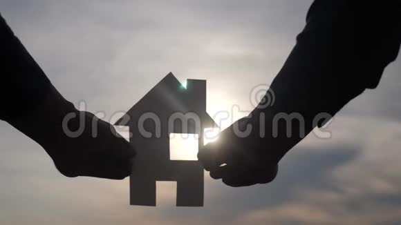 幸福家庭建设住宅理念在夕阳的余晖下一个人手里拿着一个纸房子生活视频的预览图