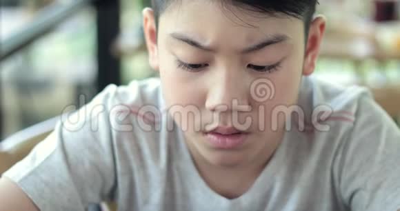 亚洲男孩玩智能手机游戏视频的预览图