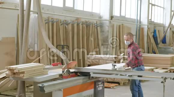 一名男子在机器上锯木门毛坯生产村内门视频的预览图