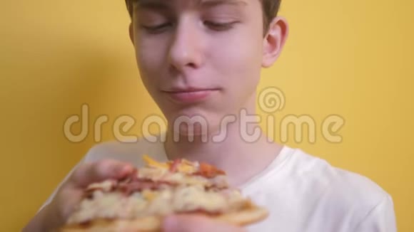 快乐的小男孩吃一片披萨的概念小男孩饿了吃一片生活方式的披萨慢速视频视频的预览图