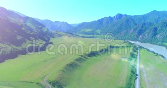 阳光明媚的夏季早晨空中乡村山路和草地沥青公路和河流视频的预览图