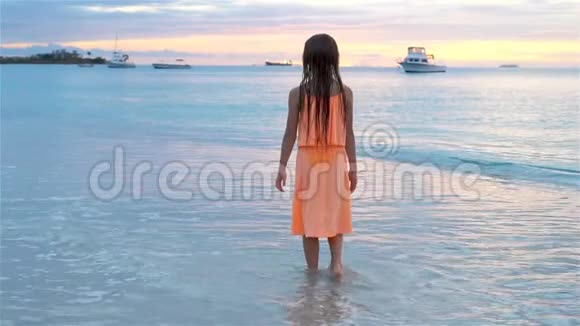可爱的快乐小孩在日落时在白色海滩上玩视频的预览图