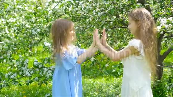 春天盛开的苹果树花园里可爱的小女孩视频的预览图