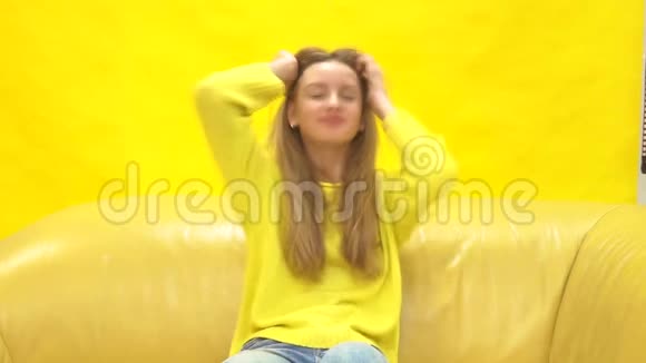 年轻的金发女郎黄色背景视频的预览图
