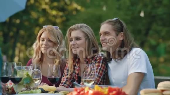 野餐派对的朋友开心地微笑着享受野餐视频的预览图