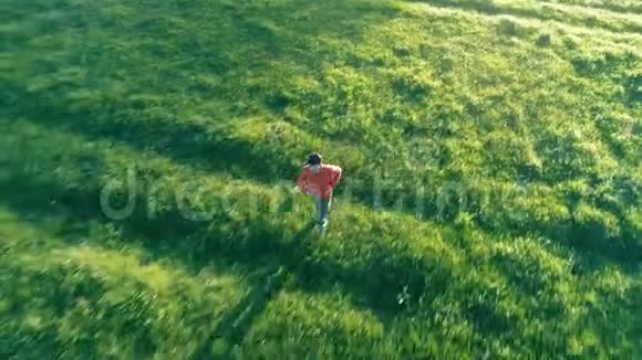 飞越运动男子跑在完美的绿色草地农村草地越野山上日落视频的预览图