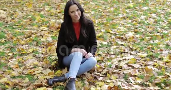微笑的女人坐在草地上视频的预览图