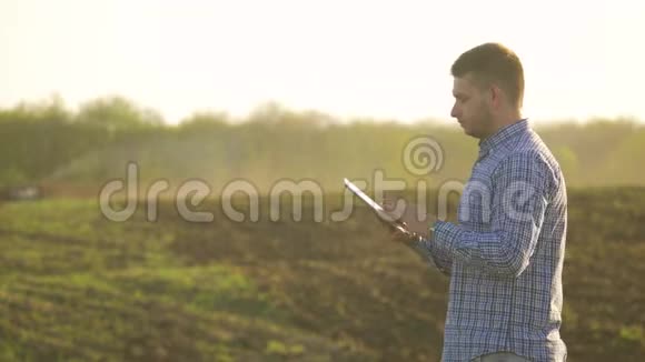 一位年轻漂亮的农民学生在田里干活手里拿着一台拖拉机手里拿着一块平板电脑快乐泥土视频的预览图