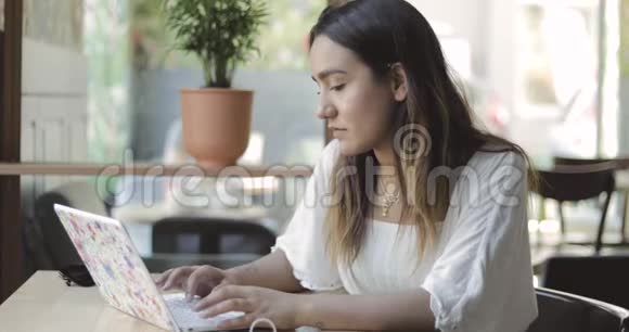 在笔记本电脑上工作的严肃的年轻女人视频的预览图