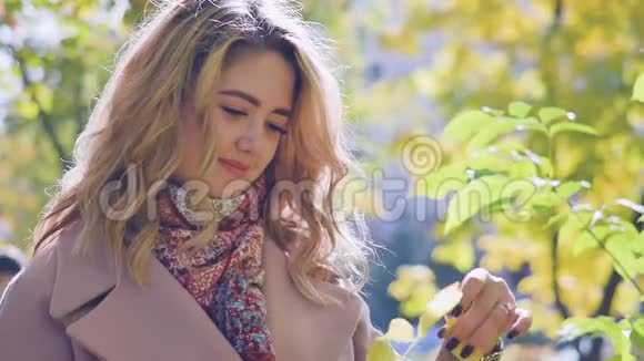 一位年轻美丽的妇女在公园里欣赏秋天的肖像视频的预览图