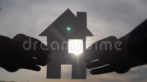 幸福家园建设理念在夕阳的余晖下一个人手里拿着一个纸房子生活视频的预览图