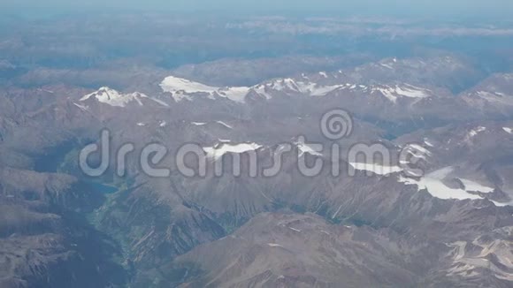 在夏季飞越阿尔卑斯山冰川的景观从飞机窗口可以看到空中景色视频的预览图