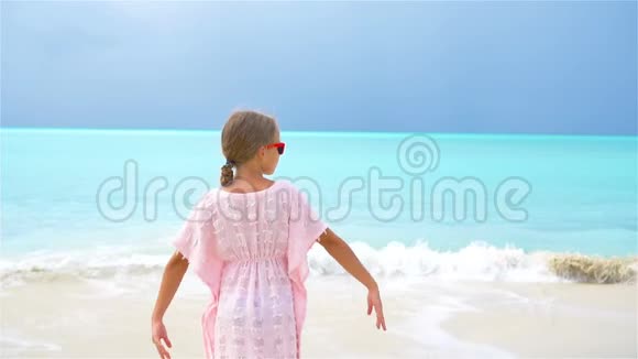 可爱的小女孩在热带海滩度假时玩得很开心流动人口视频的预览图