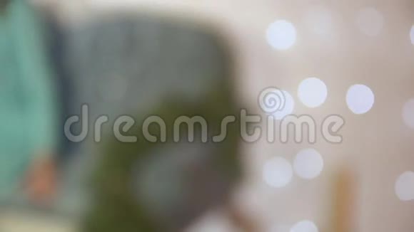 女人坐在一张豪华沙发上靠近白色砖墙装饰着花环视频的预览图