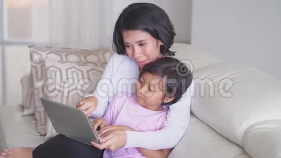 快乐的小女孩和妈妈用笔记本电脑视频的预览图