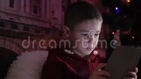 一个拿着圣诞树上的平板电脑的男孩视频的预览图