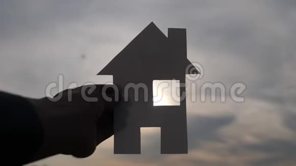 幸福家庭建设住宅理念在夕阳的余晖下一个人手里拿着一个纸房子生活视频的预览图