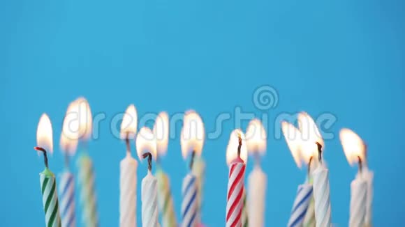 生日蜡烛在蓝色背景上燃烧视频的预览图