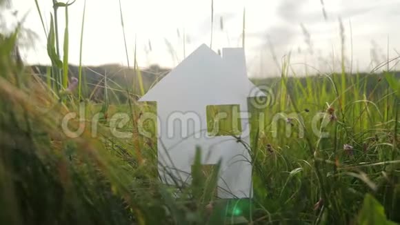 建设幸福家庭生活方式建设民宿理念纸屋矗立在大自然的绿草中象征生命视频的预览图