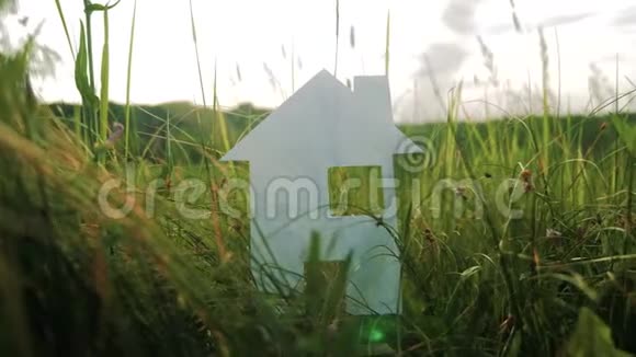 构建幸福家庭建设生活方式屋理念纸屋矗立在大自然的绿草中象征生命视频的预览图