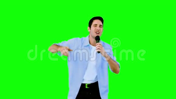 在绿色屏幕上对着麦克风唱歌的人视频的预览图