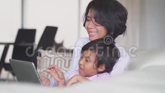 年轻的母亲和女儿用笔记本电脑视频的预览图