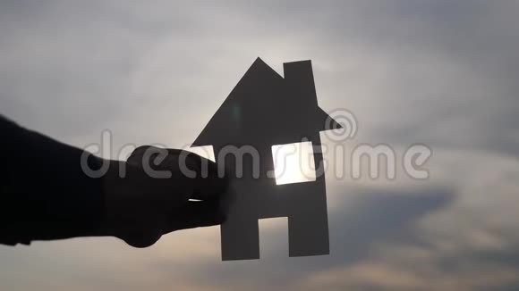 幸福家庭建设住宅理念一个男人抱着家手里拿着生活方式的纸房夕阳下的剪影视频的预览图