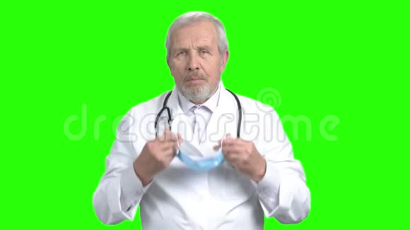 高级医生戴上医用防护面罩视频的预览图